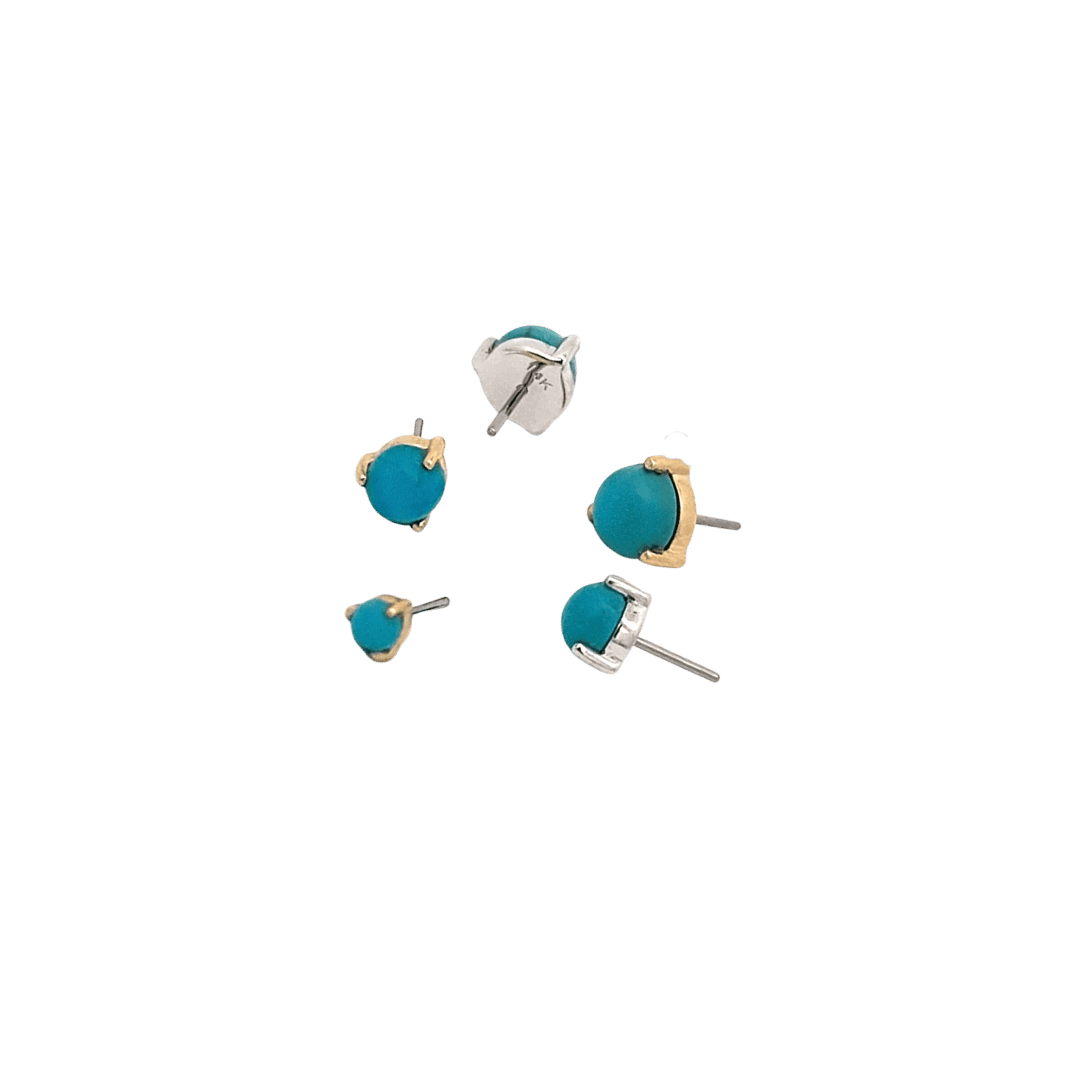 Turquoise earrings with gold and silver posts on a black background