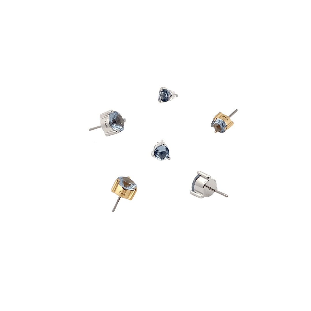 Set of small stud aquamarine birthstone earrings on a black background