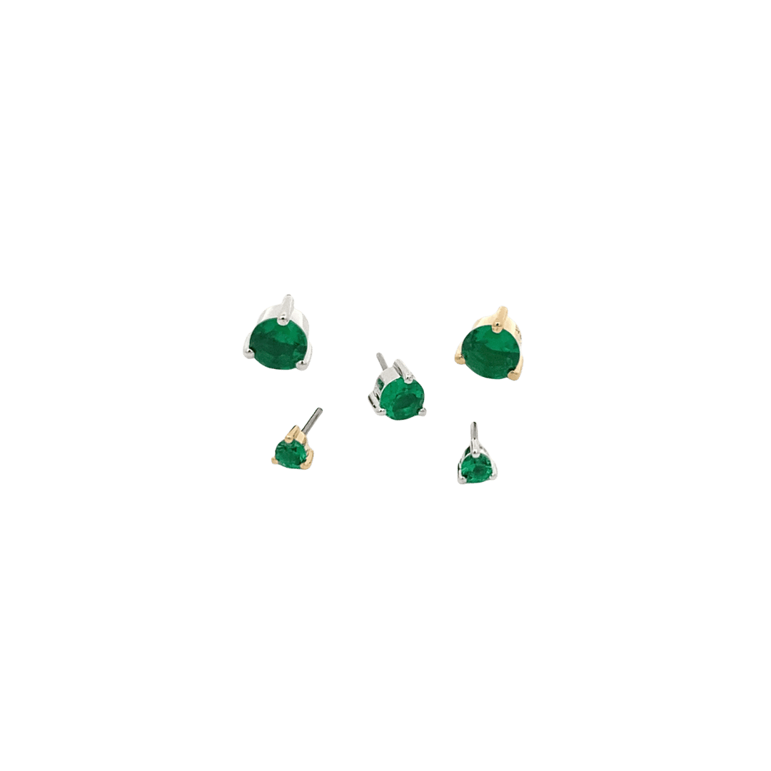 Set of May birthstone emerald earrings on a black background