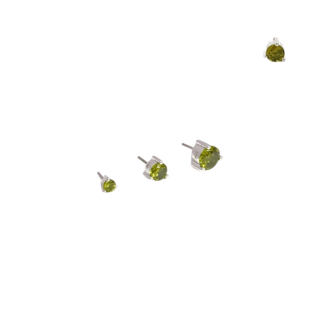 Four pairs of stud earrings with green gemstones on a black background