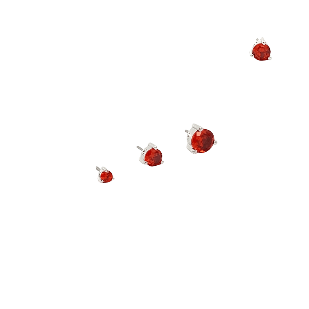 Red gemstone stud earrings on a black background